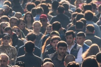 Crowd of people walking in a large city.